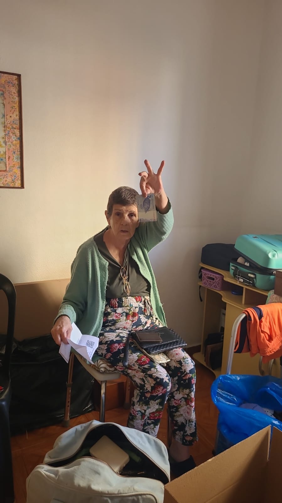 Solange achando dois reais no meio das caixas da mudança.
